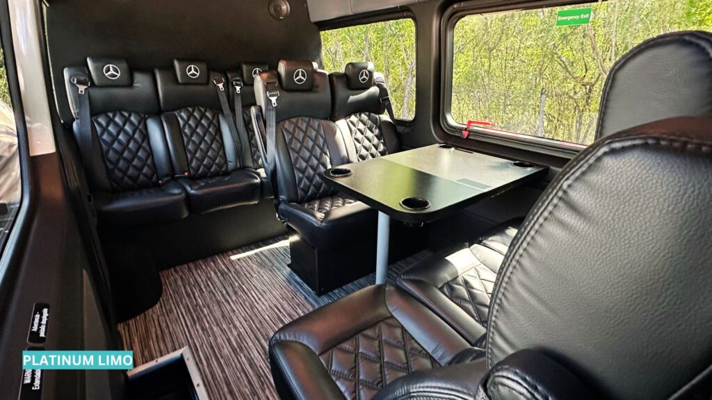 Luxurious empty interior of a late-model Mercedes Sprinter van with plush leather seating, soft accent lighting, and spacious aisle designed for premium chauffeured transportation.